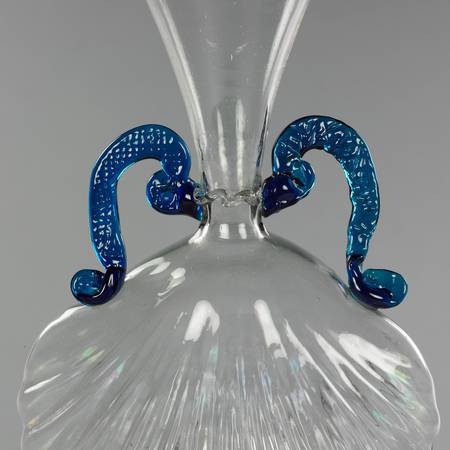 Close up detail of a Venetian glass vessel with blue glass handles