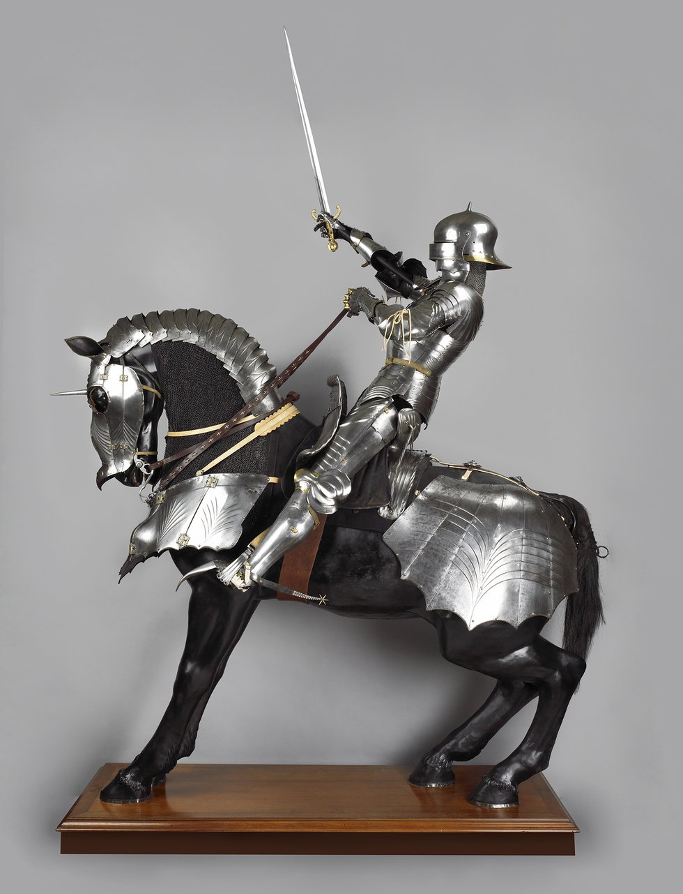 Full length photograph of a medieval knight on an armoured horse from the left