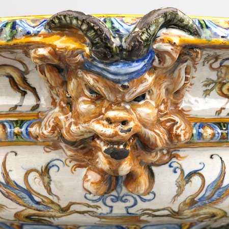 Detail of ceramic wine cooler with monsters face with horns