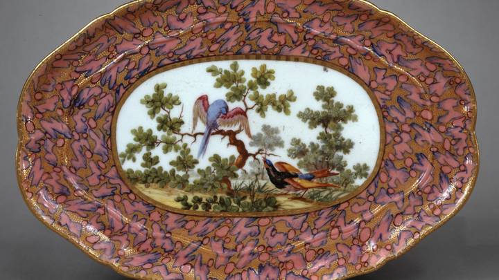 Plate from a tea service with pink and gold surrounding an image of birds in a tree