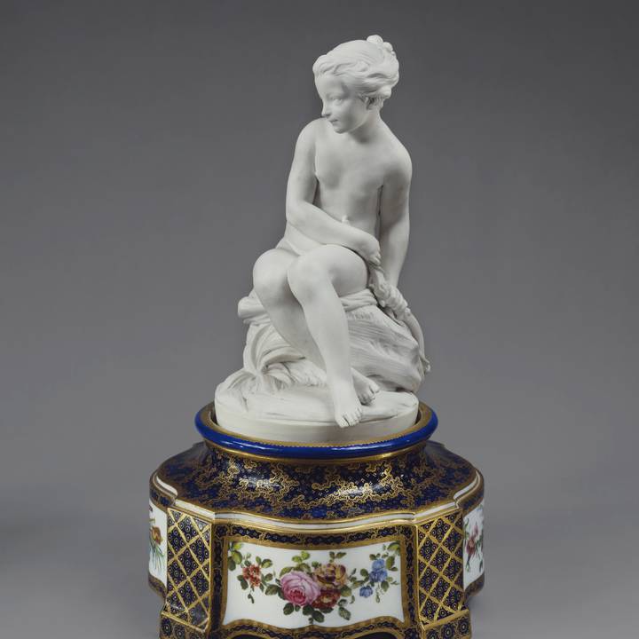 Porcelain sculpture of young women on floral painted pedestal