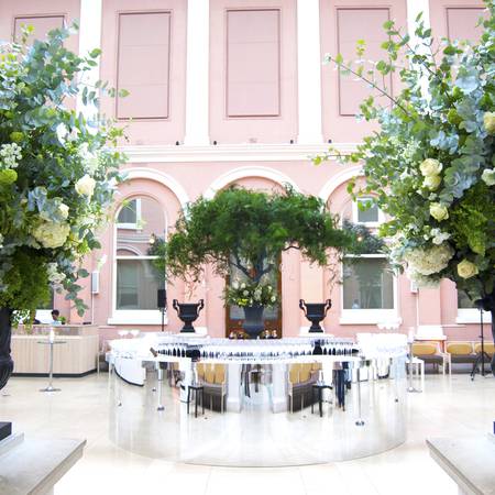 Courtyard with a central drinks bar flanked by floral displays