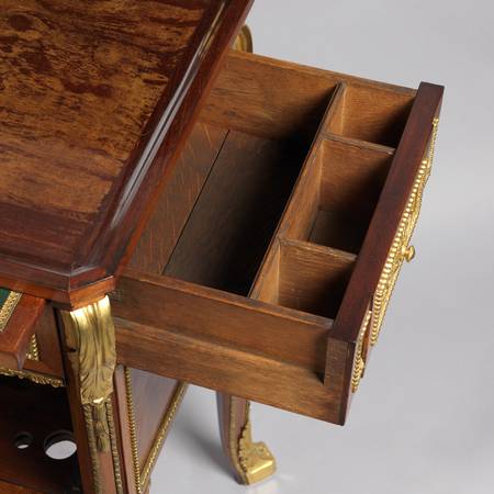 A detail of the inside of a drawer of a mahogany-veneered writing and toilet table