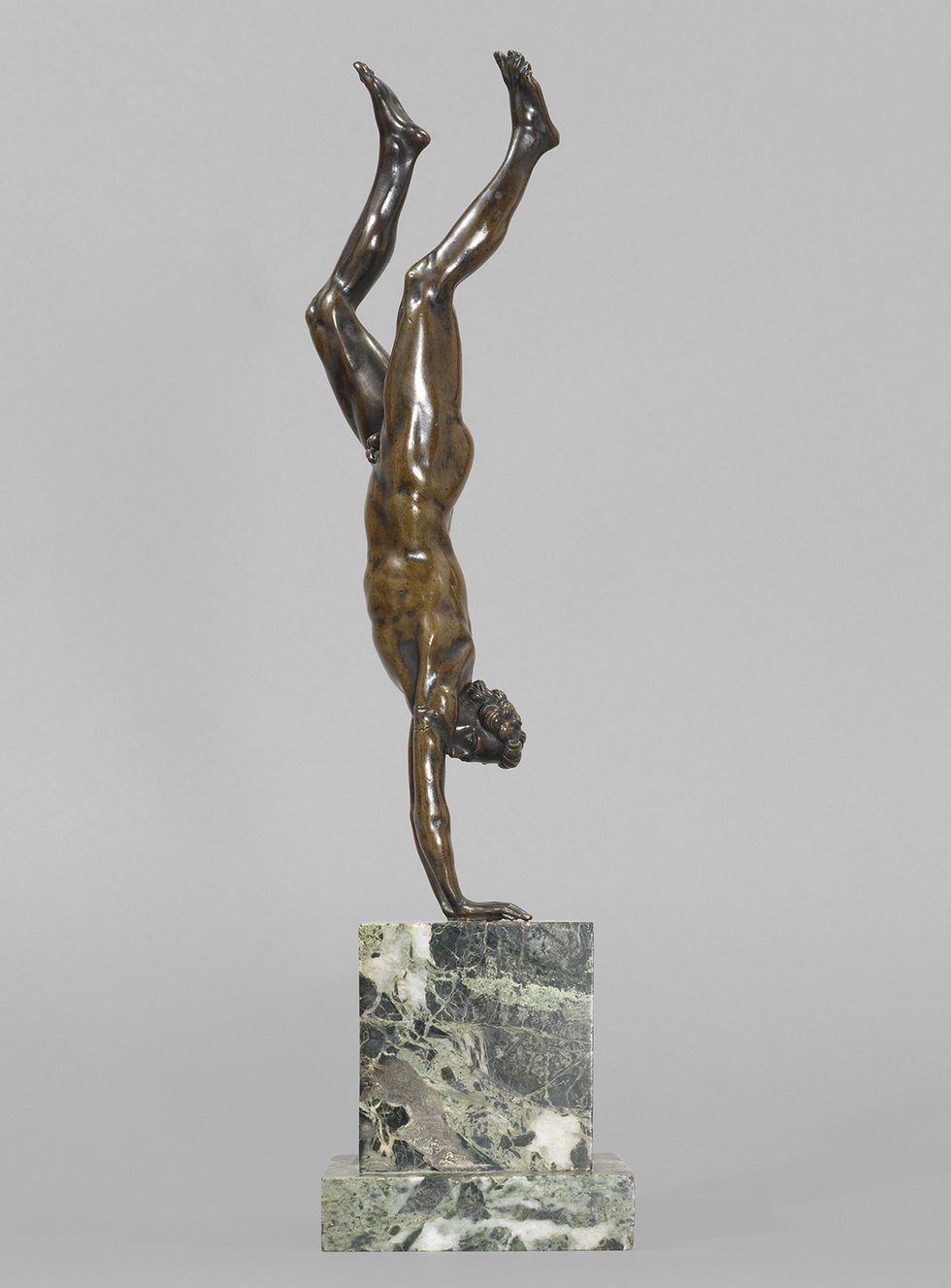 Bronze sculpture of naked man doing a handstand
