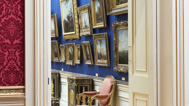 View through a door frame of paintings on gallery wall