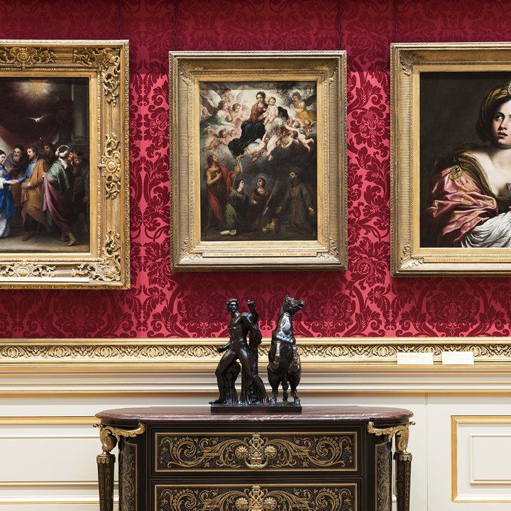 Three paintings and cabinet with figure statue on in museum interior